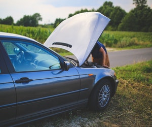 A man on the road repairing his broken car